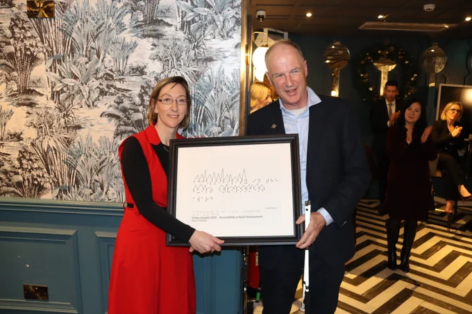 Paul O’Rahilly accepts his Accessibility in Built Environment tactile Award  from June Tinsley