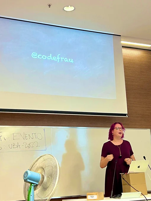 Me in front of a slide with my Twitter handle