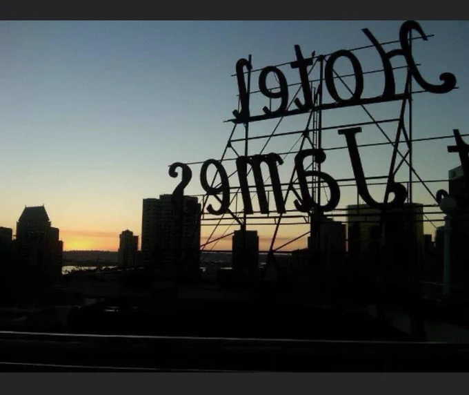 Sunset view from atop a hotel with silhouette view of hotel sign.