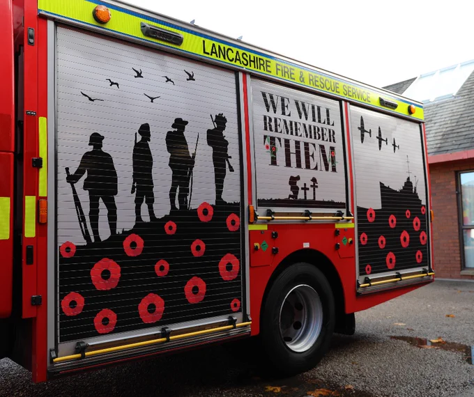 Remembrance fire engine with poppies, as well as silhouettes of soldiers and military vehicles. Text reads: "We will remember them"