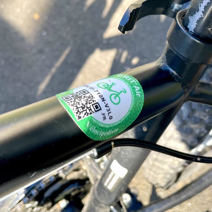 Un sticker à fond blanc appliqué sur un cadre de vélo enfant.