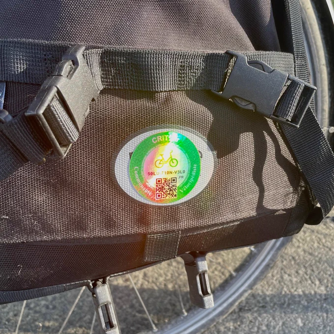 Un sticker holographique appliqué sur une sacoche avec un support semi-rigide.