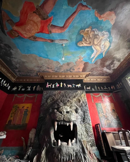 The spectacular Lion Room dominated by a fearsome roaring lion fireplace where the late Ron Gittins used to cook Roman Army-style pancakes. The walls and ceiling are covered in friezes and murals depicting Roman scenes. Image by Martin Wallace.