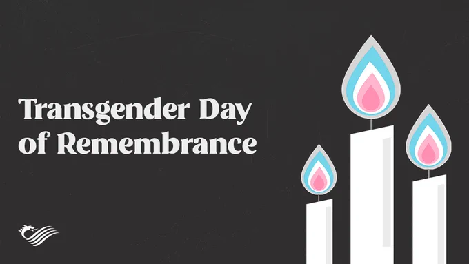 Three candles with flames in white, pale pink and pale blue which are the colours of the Transgender Flag. The Transgender Flag has horizontal pale blue and pale pink stripes with a single white stripe in the middle.