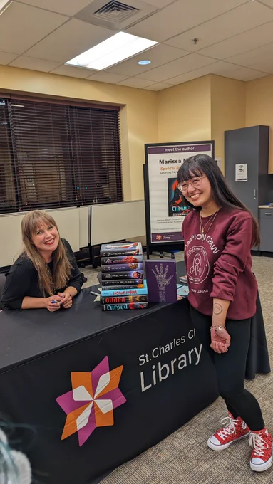 Reader with Lunar Chronicles-inspired tattoo smiles with author Marissa Meyer