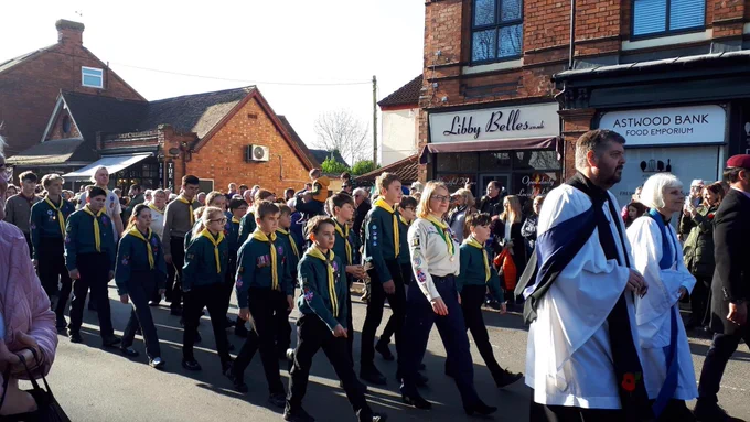 Group of Scouts walking behind two vicars on parade