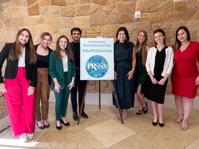 National Committee standing with a World Kindness Day sign. The sign reads "Celebrating World Kindness Day. #BePRSSAKind."