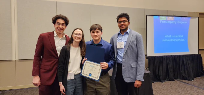 Four students holding a certificate for winning 1st place in Chemical engineering Jeopardy