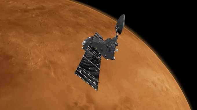 Illustration of the European Space Agency’s Trace Gas Orbiter in orbit around Mars. The vehicle features long solar panels extending from either side of a central spacecraft bus, with a communications antenna pointing to the right. Credit: ESA/ATG medialab