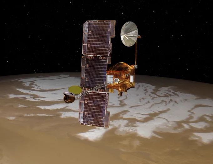 Illustration of NASA’s Mars Odyssey spacecraft in orbit at Mars. The planet’s south polar ice cap is visible behind the orbiter, which features a large, offset solar panel and two extended booms for science instruments and a communications antenna.