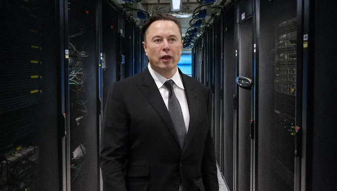 Elon Musk standing in between different computers with wires on them.