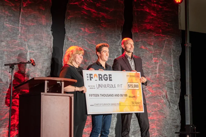 Universole Fit entrepreneur receiving $15K cheque on stage.