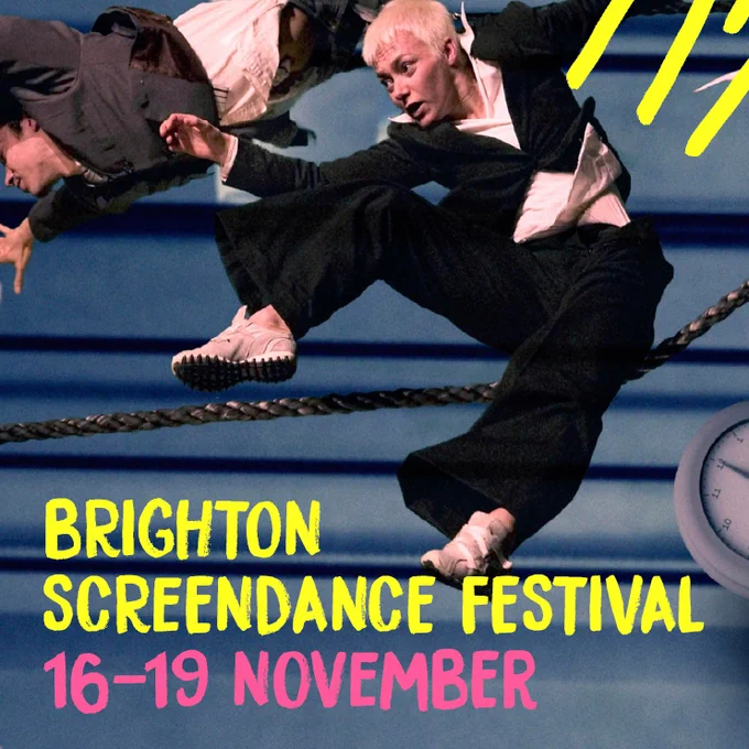 Two people in suits fall in space in front of a blue curtain. A black rope and a clock is in the background. The words Brighton Screendance Festival, and 16-19 November are written over the image.