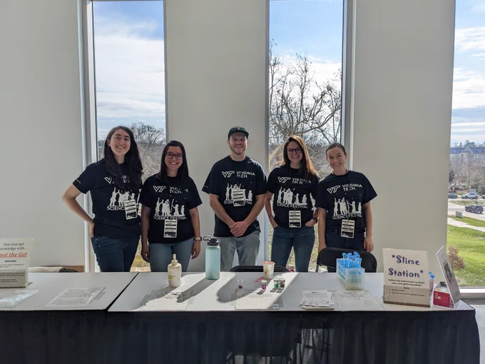 5 Moore group members stand behind their slime station exhibit