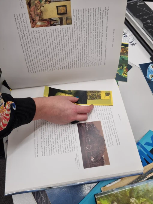 A book mark being placed in a large art book