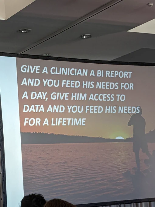 Presentation slide that reads "Give a clinician a BI report and you feed his needs for a day, give him access to data and you feed his needs for a lifetime"