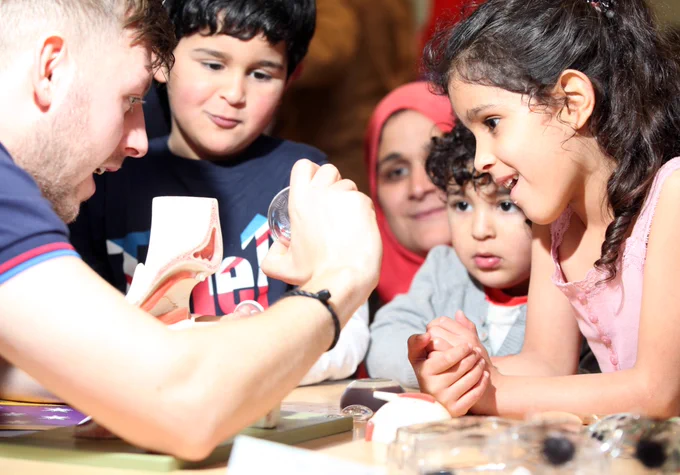 A group of children looking in wonder at a science experiment