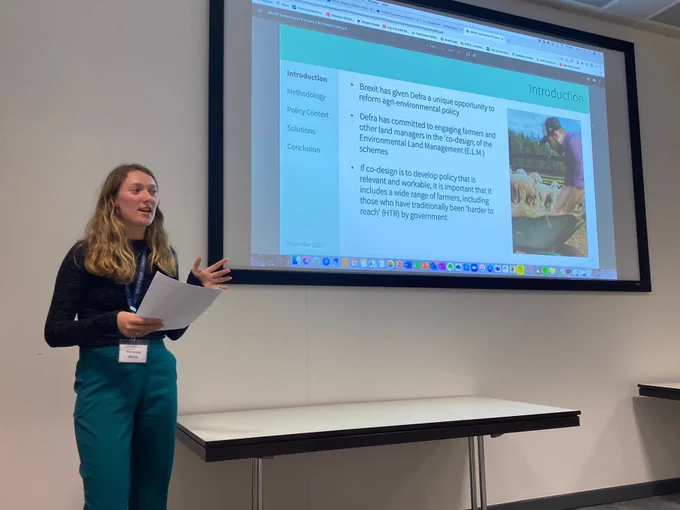 Veronica stands in front of her presentation slides