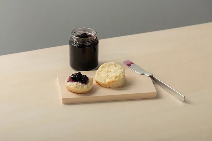 Image depicting Kathleen Reilly's knife design at rest on a wooden plate with jam and scones. Credit: Kakeru Ooka & Ooki Jingu