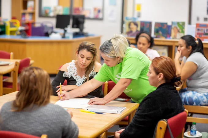 An instructor assists parents in a Coates Family Academy night class about ways to support your child's education.