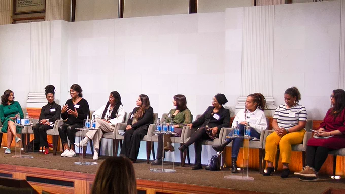 Social Business Impact Programme cohort sitting on stage at the pilot launch event.