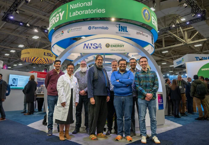 Members of the GenSLMs team gather in front of DOE's SC22 booth.