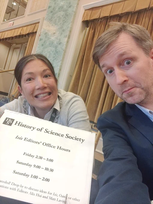 The HSS editors smile while holding a sign listing the aforementioned office hours.