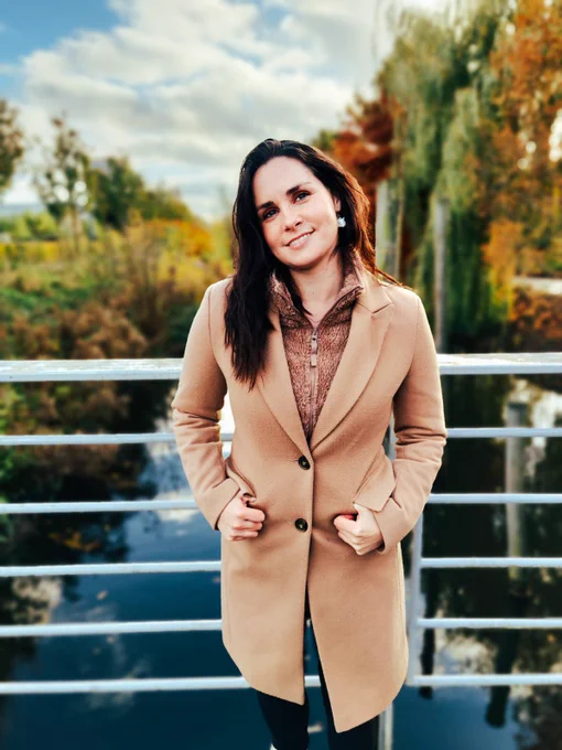 Photo of turtletickles in front of a canal with trees in the background displaying Autumn foliage