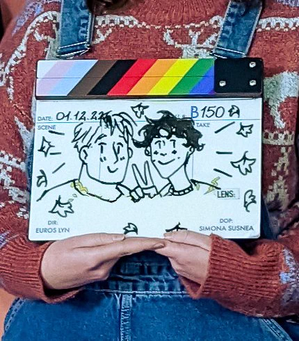 Photo of the Heartstopper Season 2 clapper, with drawings of Nick and Charlie on it