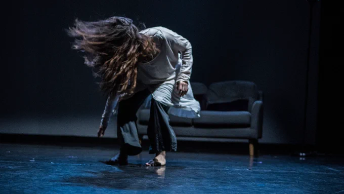 A dancer on stage flinging back her hair