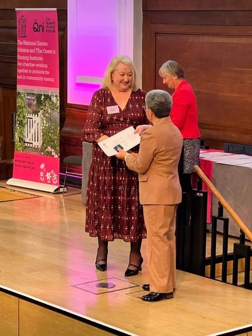 Kathy receiving her certificate on-stage at the awards ceremony