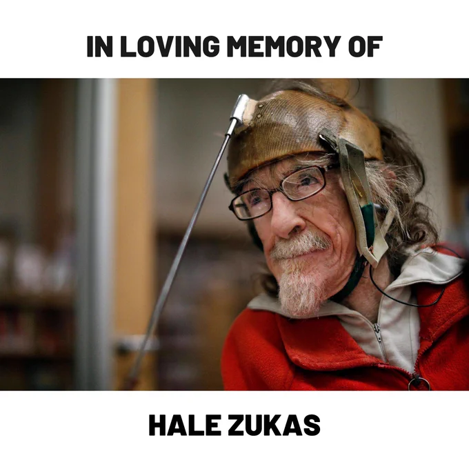 Graphic with text that reads "IN LOVING MEMORY OF." Below is a photo of Hale Zukas at the Berkeley Library. He is wearing an assistive technology device. Below the photo is text that reads "HALE ZUKAS."