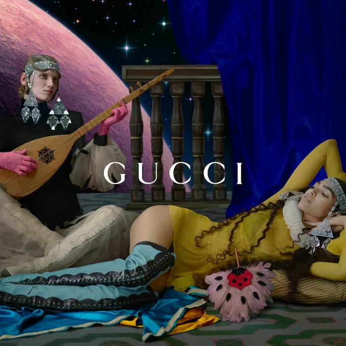 In a montage, a white woman sits cross-legged on a carpet playing an antique lyre with her pink lace-gloved hands. Wearing white thigh-high lace-up boots and a black dress with white tulle sleeves and skirt, her blond hair is in an elaborate updo under a filigree metal headpiece with geometric pendants. She is flanked by two legs, a cloud of white tulle, and an ottoman with incense and rose water, with a nearby purple planet and black starry sky appearing beyond a painted balustrade. The Gucci script logo appears in white superimposed over the center of the image.   
 In a montage, a woman with very long brown hair in finger curls under a white filigree metal headpiece, wearing a yellow mini dress and a ruff collar, reclines on a pillow on the floor. She has light blue thigh-high lace-up boots, and there are blue and yellow silks along with a pink feather fan in the foreground. 