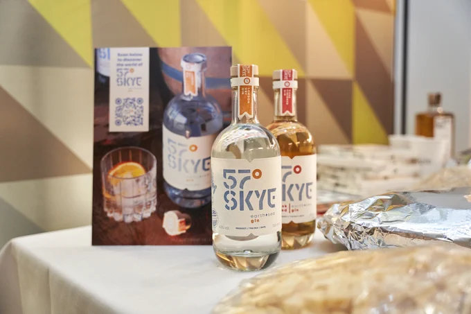 A photograph of 57 Skye showcase table featuring two bottles of gin and a tray of cheese and branding leaflets