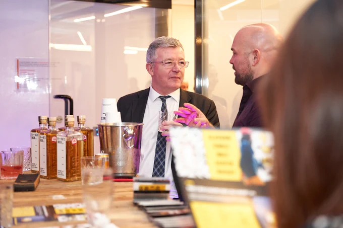 A photograph of two guests standing by the Kings Inch showcase table
