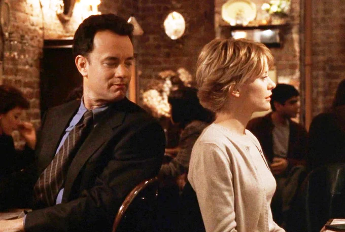 Tom Hanks looks over Meg Ryan's shoulder, in a still from the film You've Got Mail.