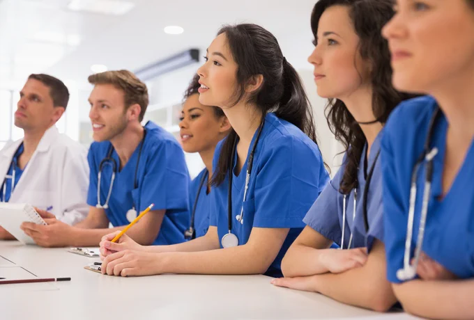 Nursing students in blue scrubs.