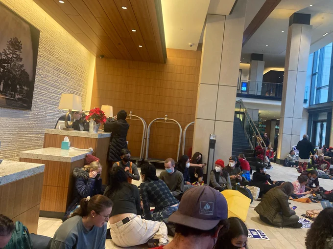 A group of striking Academic Workers occupies the lobby of the UCLA Luskin Conference Center.