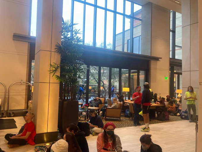 A group of striking Academic Workers occupies the lobby of the UCLA Luskin Conference Center.