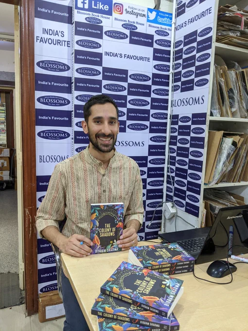 A photo of me posing with signed copies of my book at Blossoms.