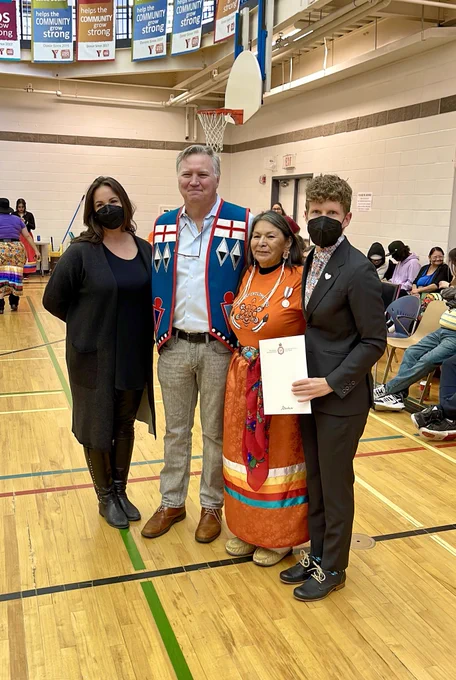Nicole, Richard, and Janis present Bernadette with her medal.
