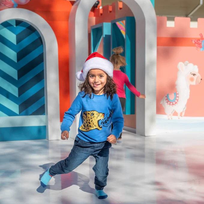 Child in Santa hat sliding in socks