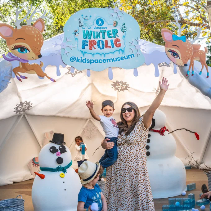 Mother and son waving in front of play snow people