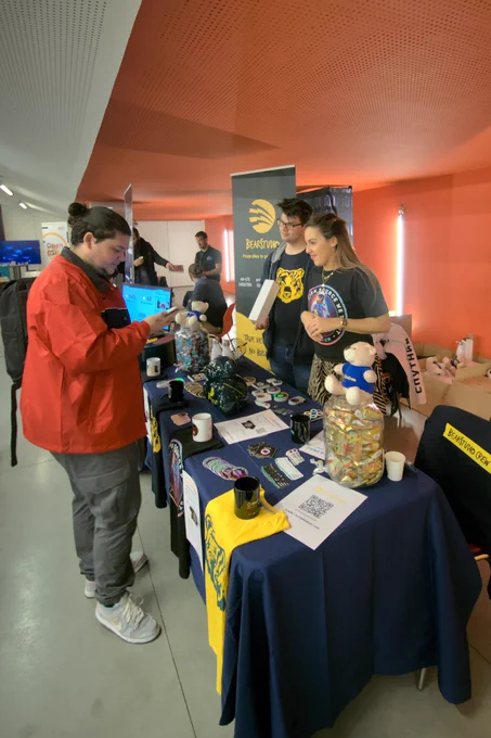 Stand du BearStudio accueillant un visiteur. Des goodies sont disséminés sur la table