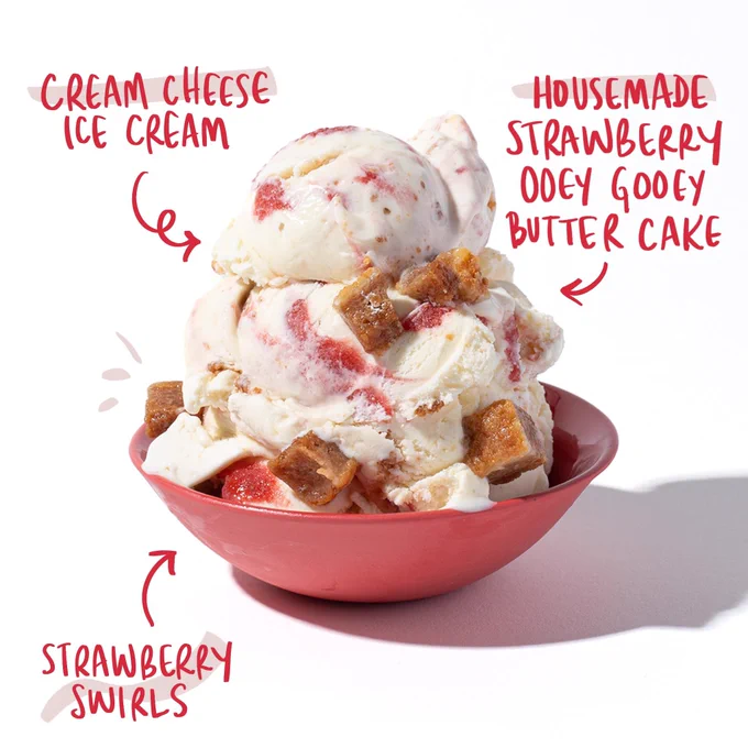 A red bowl appears on a white background with scoops of Strawbooey Gooey scoops. Arrows label features of the flavor "Cream cheese ice cream", "Housemade strawberry ooey gooey butter cake" and "strawberry swirls".