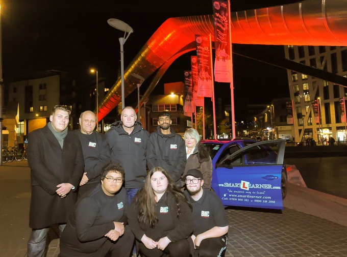 Cllrs Lloyd and Hetherton with road safety campaigners near the Whittle Arch lit up in red