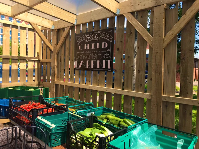 Crates of fruit and vegetables including pak choi, courgettes and tomatoes are laid out in tables in the fresh air cafe.
