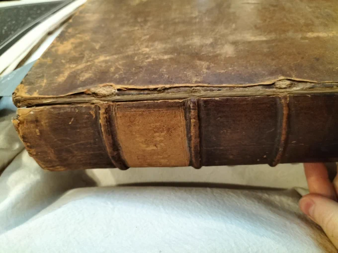 A spine of a book showing damage