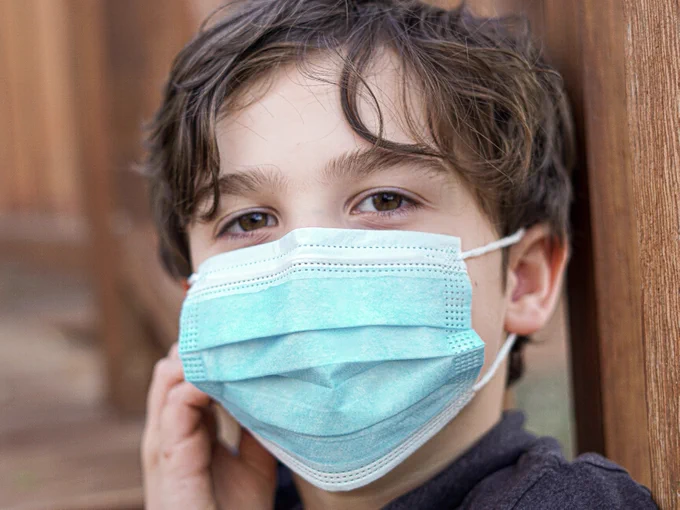A child with a blue face mask.