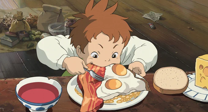 From HOWL'S MOVING CASTLE: A young boy chows down on fried eggs and bacon at an old-fashioned wooden table.